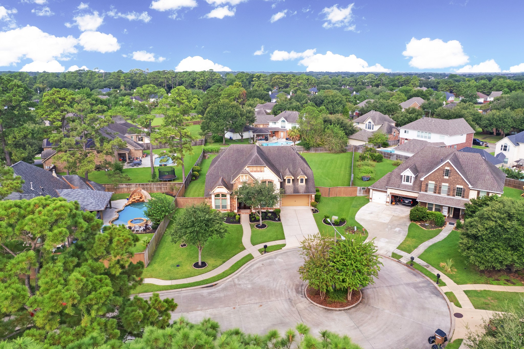The aerial tells the location story - the home sits on a mature, tree-lined cul-de-sac in Bayou Park 3, with an oversized corner lot behind it.