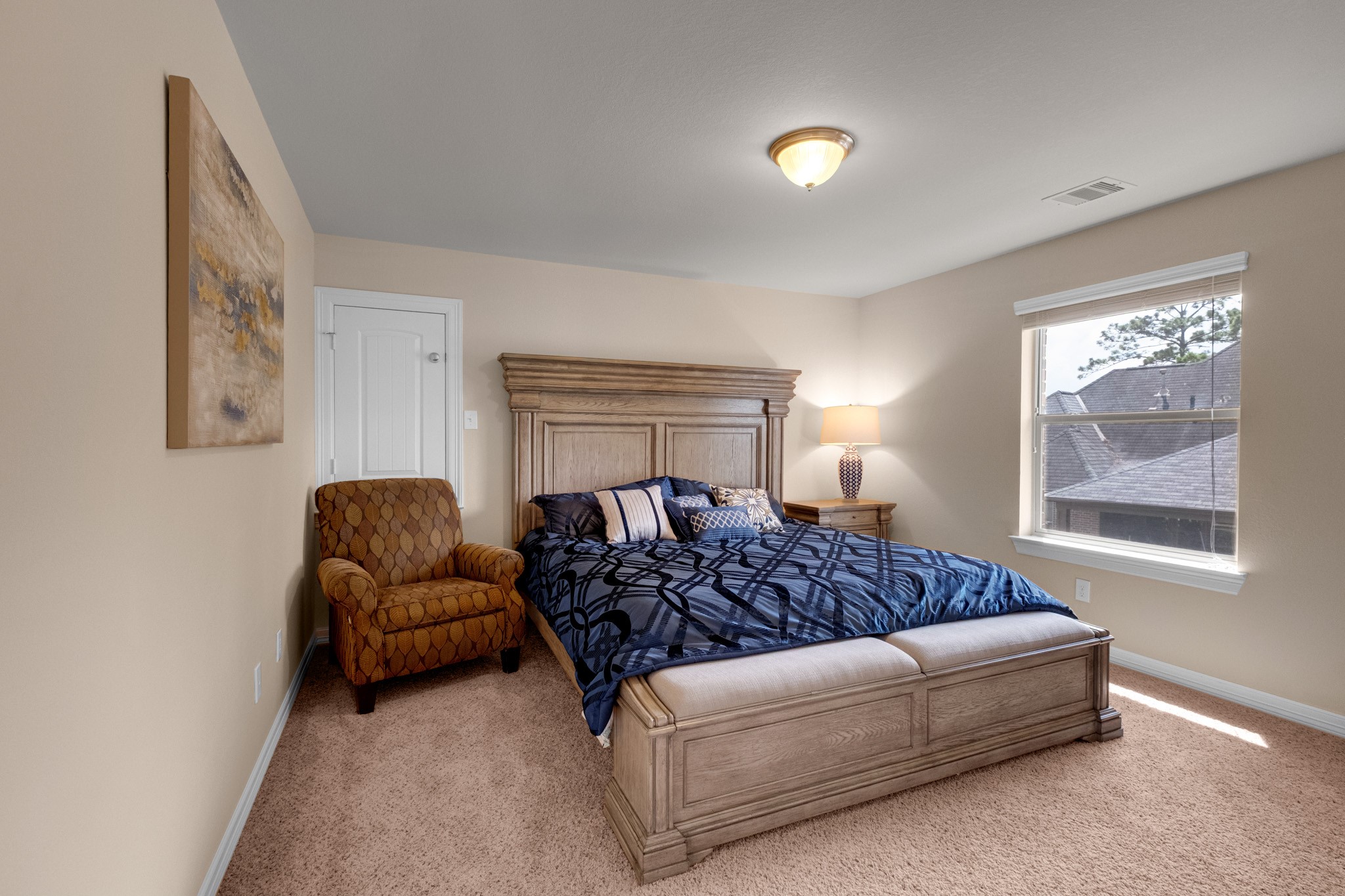 A secondary bedroom sits carpeted and quiet with a window over the treetops - comfortable proportions and a full closet.