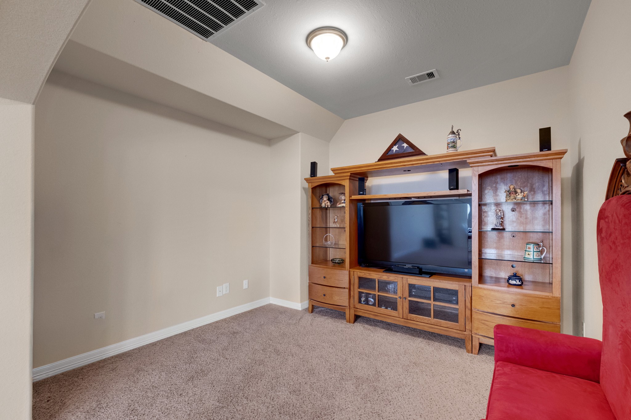 A dedicated media room sits tucked off the game room, wrapped in plush carpet with a stepped ceiling and a full wall staged for the screen - set back far enough from the landing to keep movie nights to themselves.