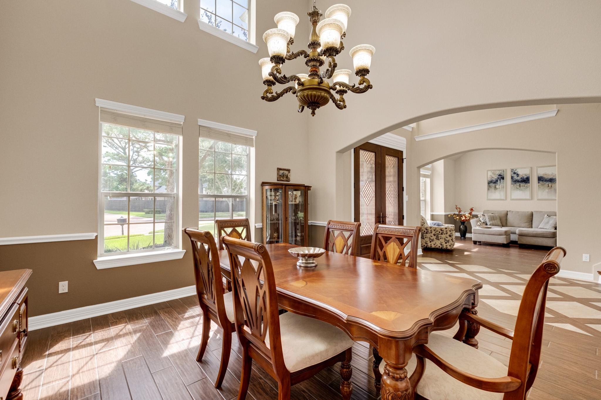 From the dining table you look straight through the arched opening to the front doors and formal living beyond - the kind of sightline that makes hosting feel effortless.