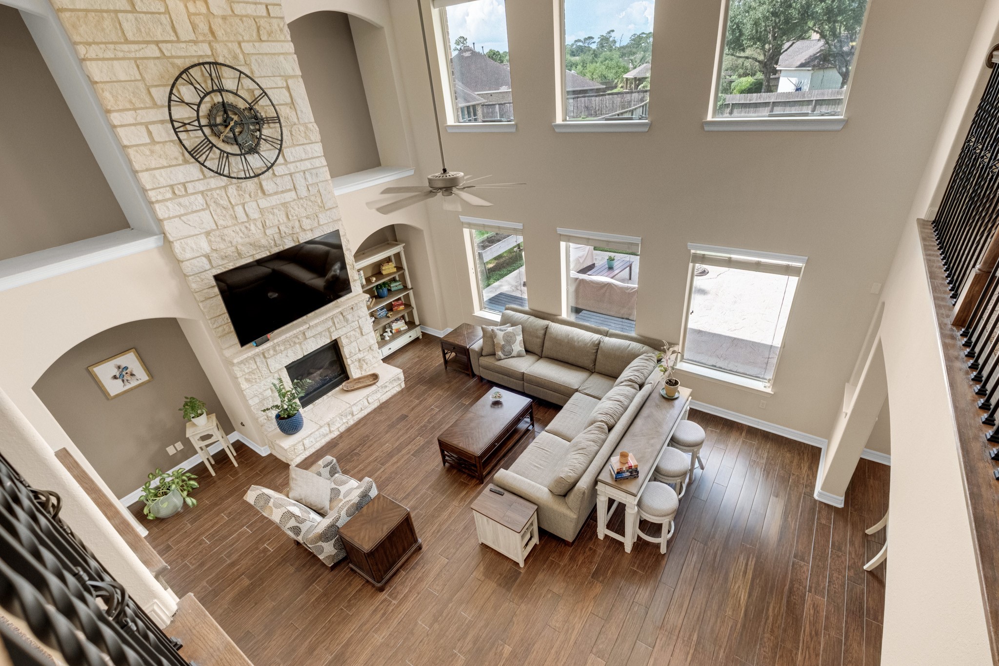 From the catwalk you get the best read on the volume - two full stories of stone chimney, stacked arched niches, and a window wall opening to the pool.