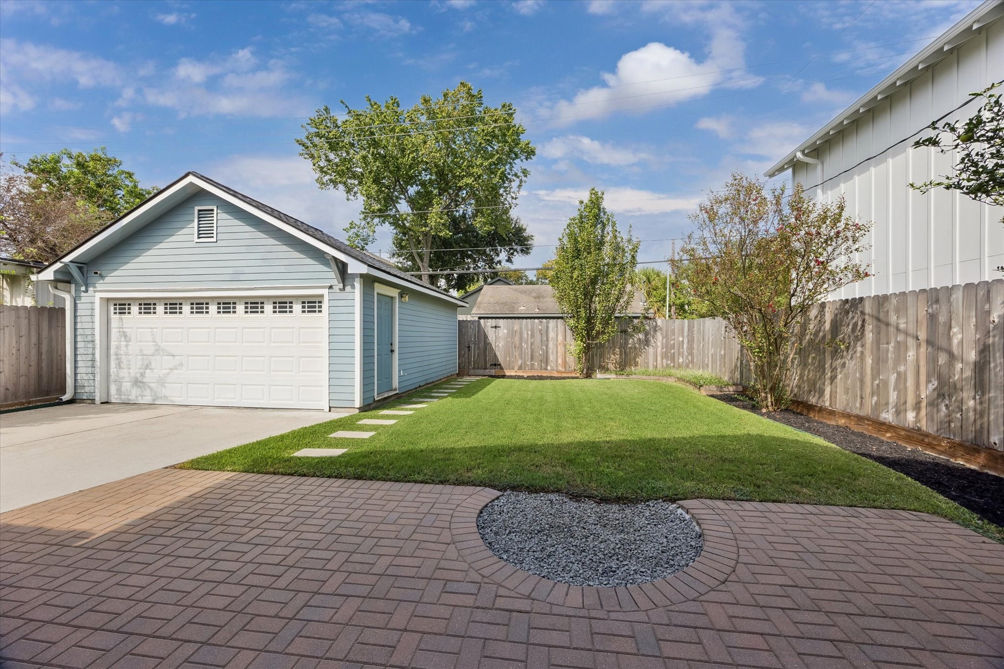 Amazing back yard space with grass, patio and two car garage