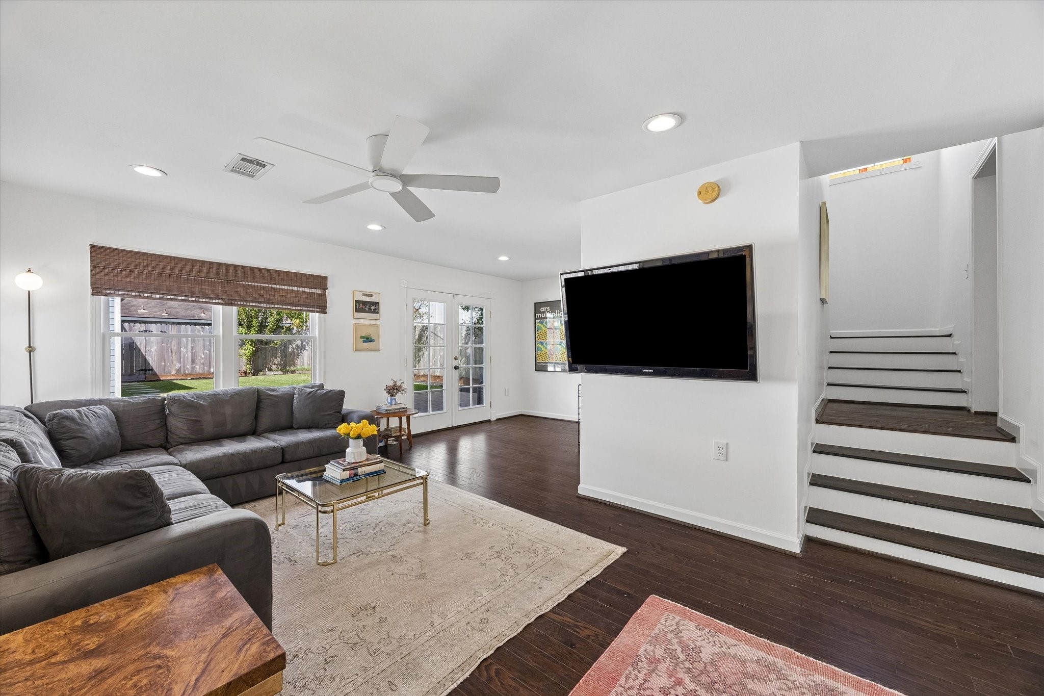 Down a few steps from the kitchen is the more casual living area with back yard access, half bath and laundry room
