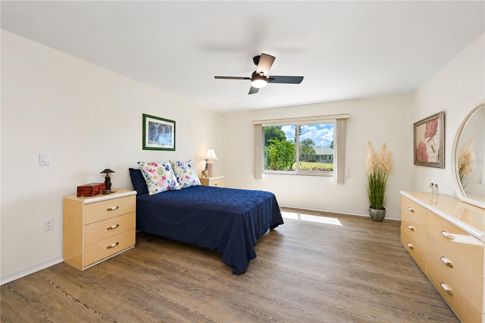 Primary bedroom can hold a king size suite  of furniture and features plank flooring