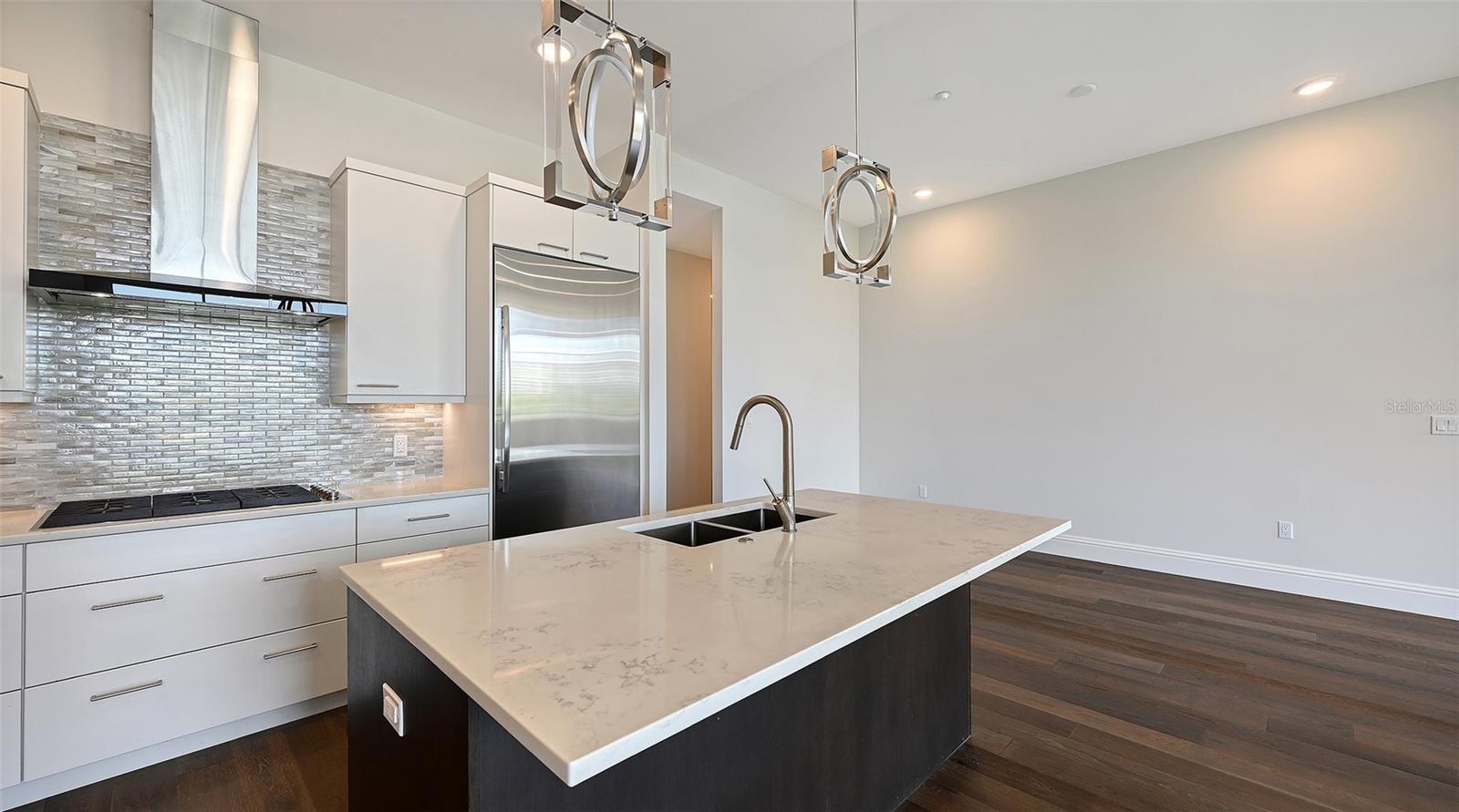 Kitchen area showing cooktop, refrigerator and into breakfast eat in area