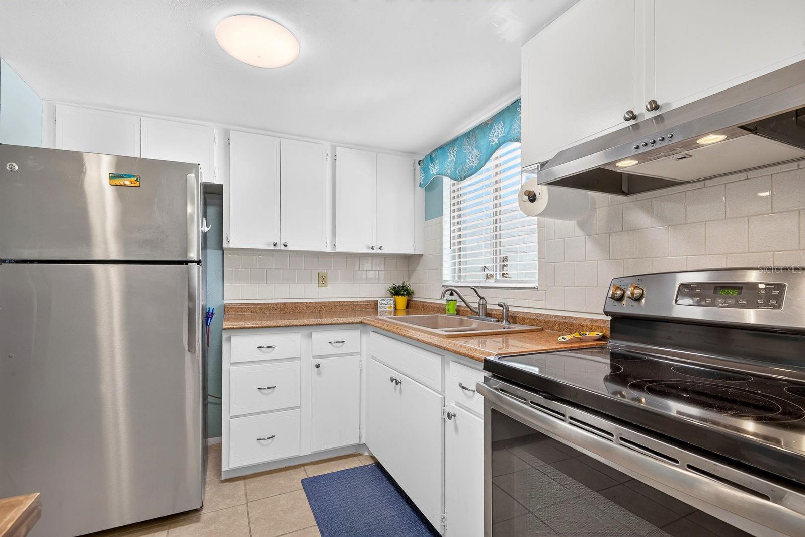 Kitchen with updated appliances and white tile back splash