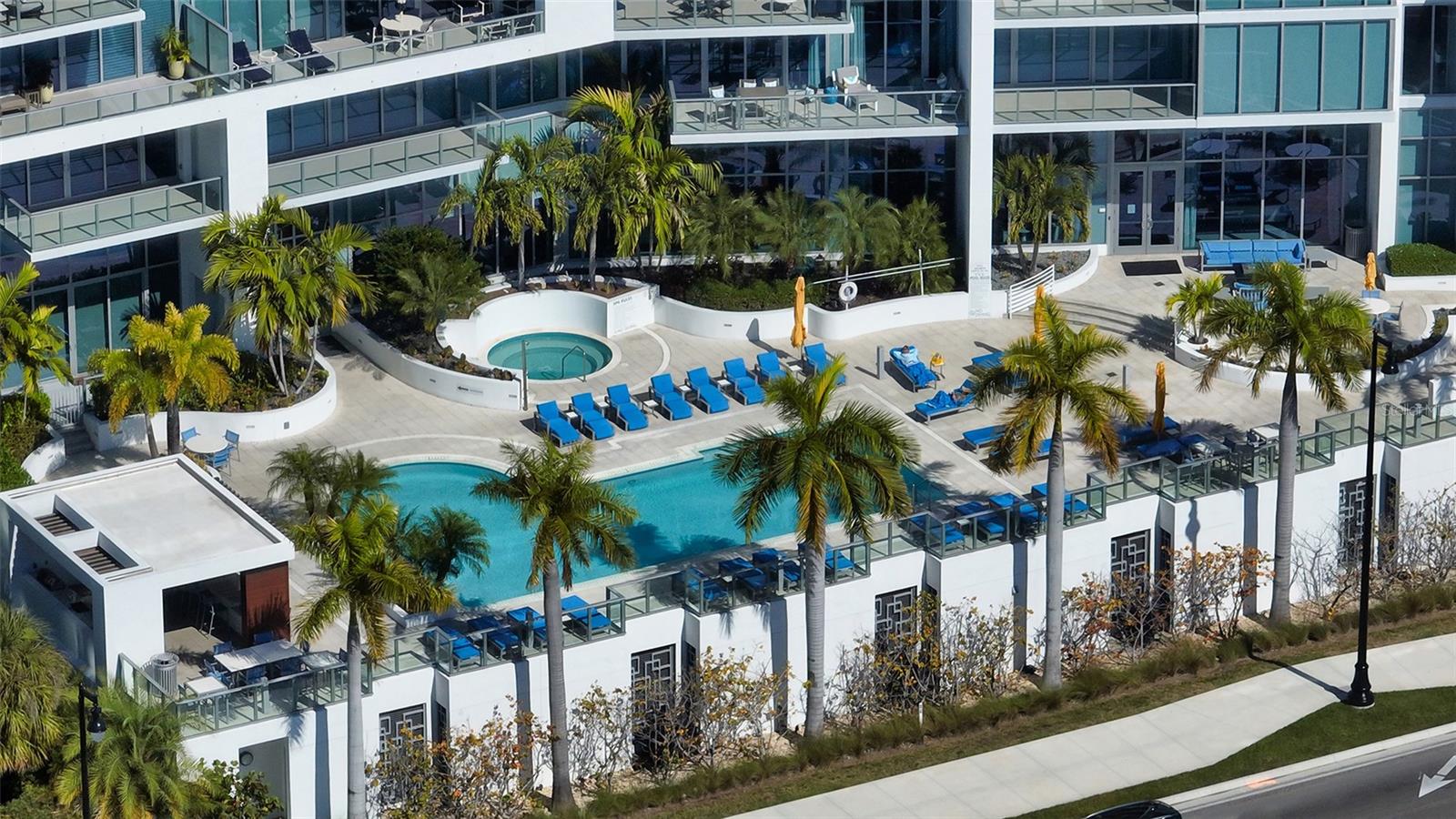 An aerial perspective showcasing The VUEs striking architecture and beautiful resort-style pool, highlighting its exceptional design and luxurious waterfront setting.