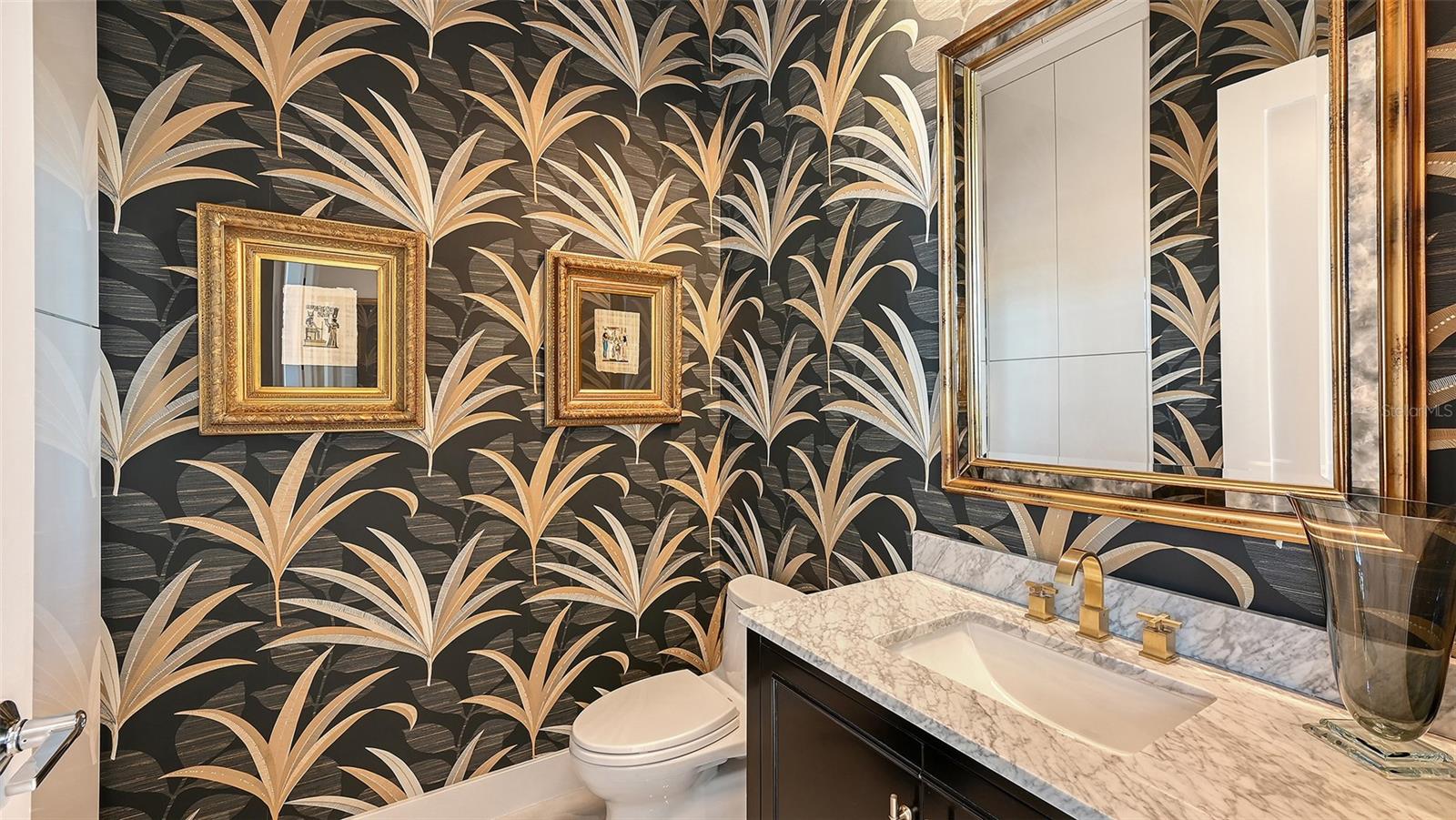 Elegant powder room adorned with exquisite designer wallpaper and refined finishes.