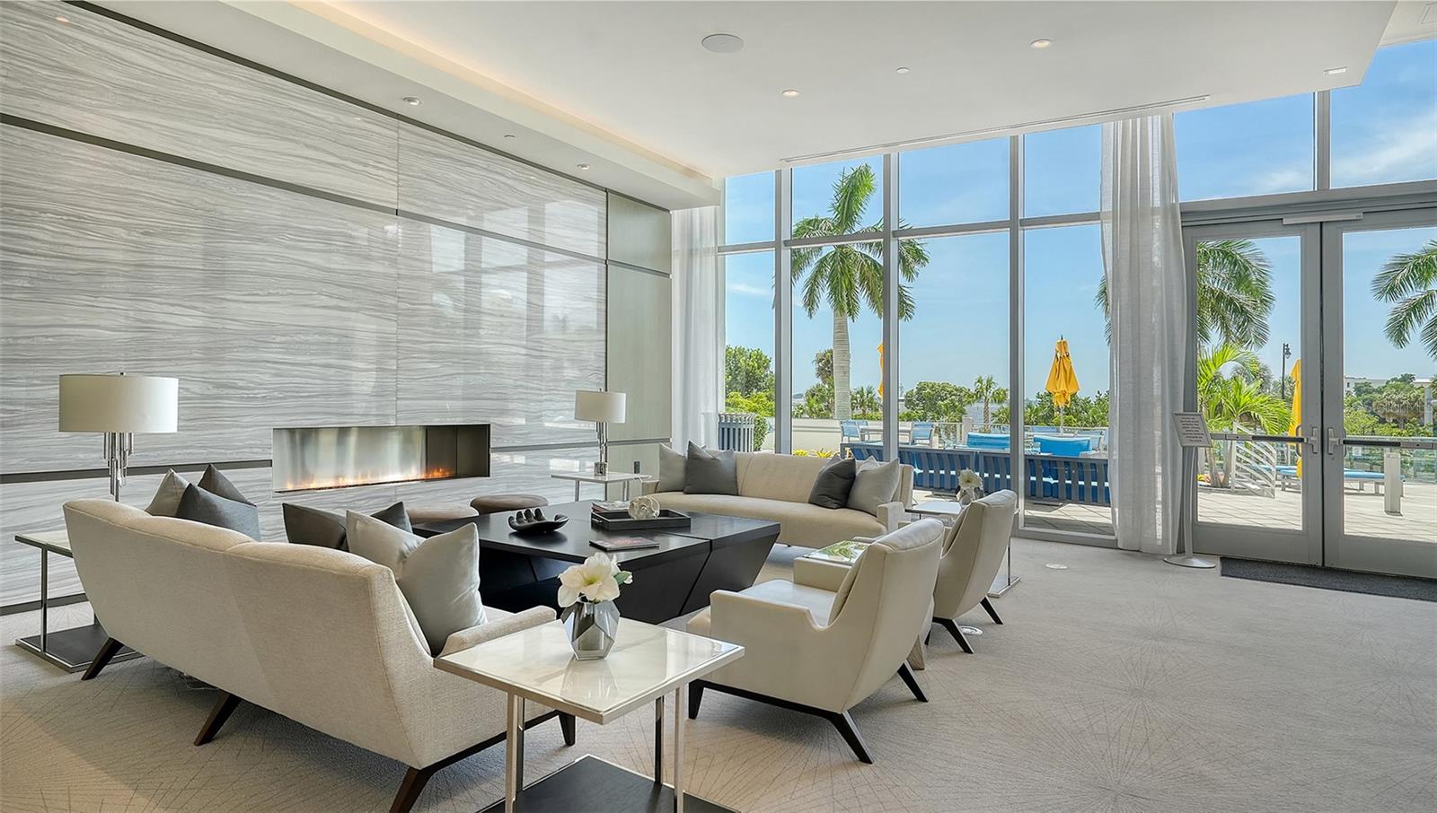 An expansive luxury lobby lounge featuring elegant seating and a welcoming fireplace, creating a sophisticated setting for relaxation and gathering with guests.