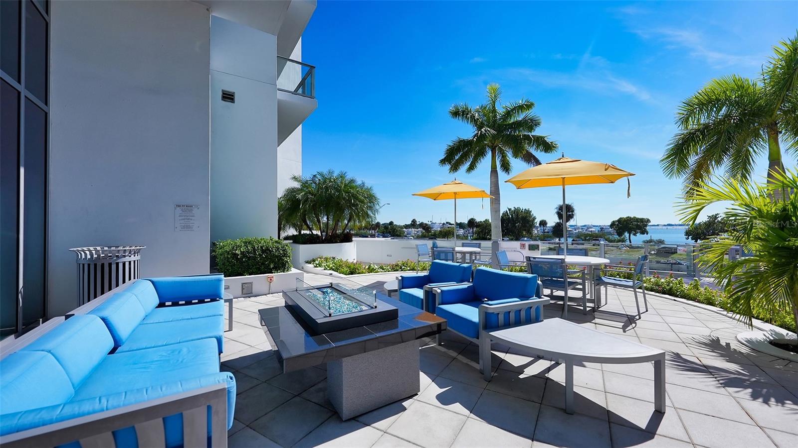 An inviting poolside seating area with a fire pit, perfect for relaxed gatherings, evening conversations, and entertaining under the stars.