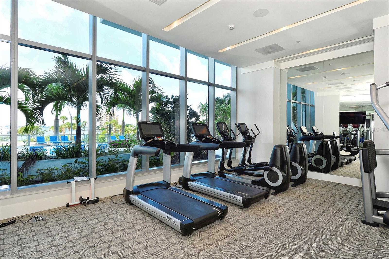 A state-of-the-art fitness center featuring panoramic views of the resort-style pool and Sarasota Bay.