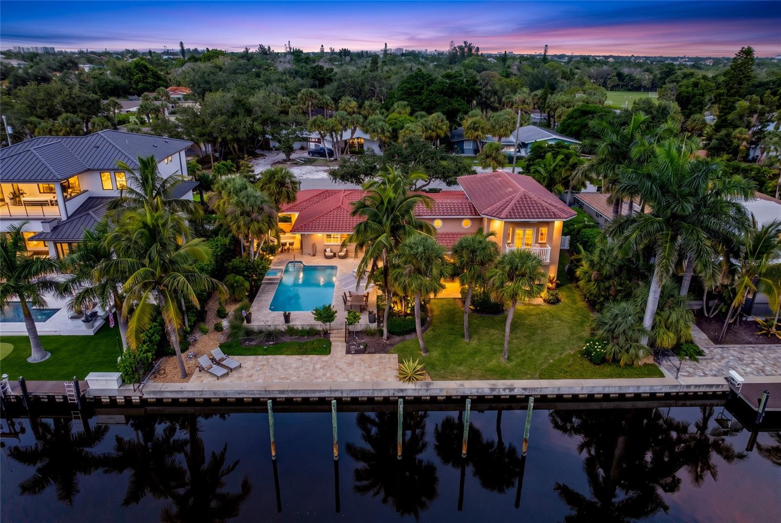 Aerial view of 5376 Shadow Lawn Drive showcasing the home's canal frontage, pool, tropical setting and Siesta Key waterfront lifestyle.