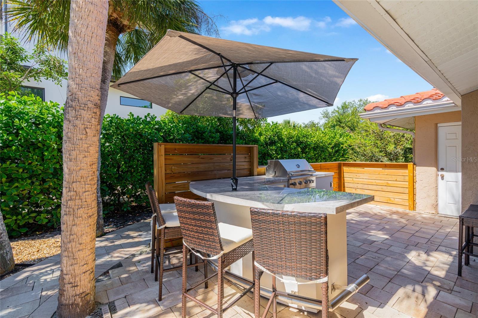 Outdoor kitchen and dining area make poolside entertaining easy and extend the home's living space outdoors.