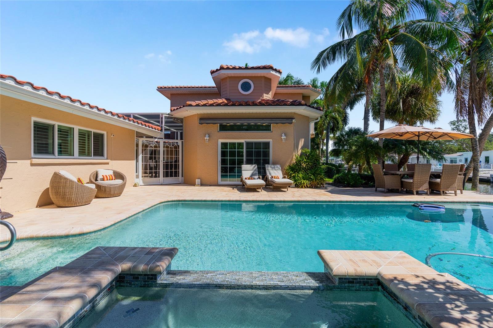 Poolside view toward the home highlights the scale of the outdoor living area and lush tropical surroundings.