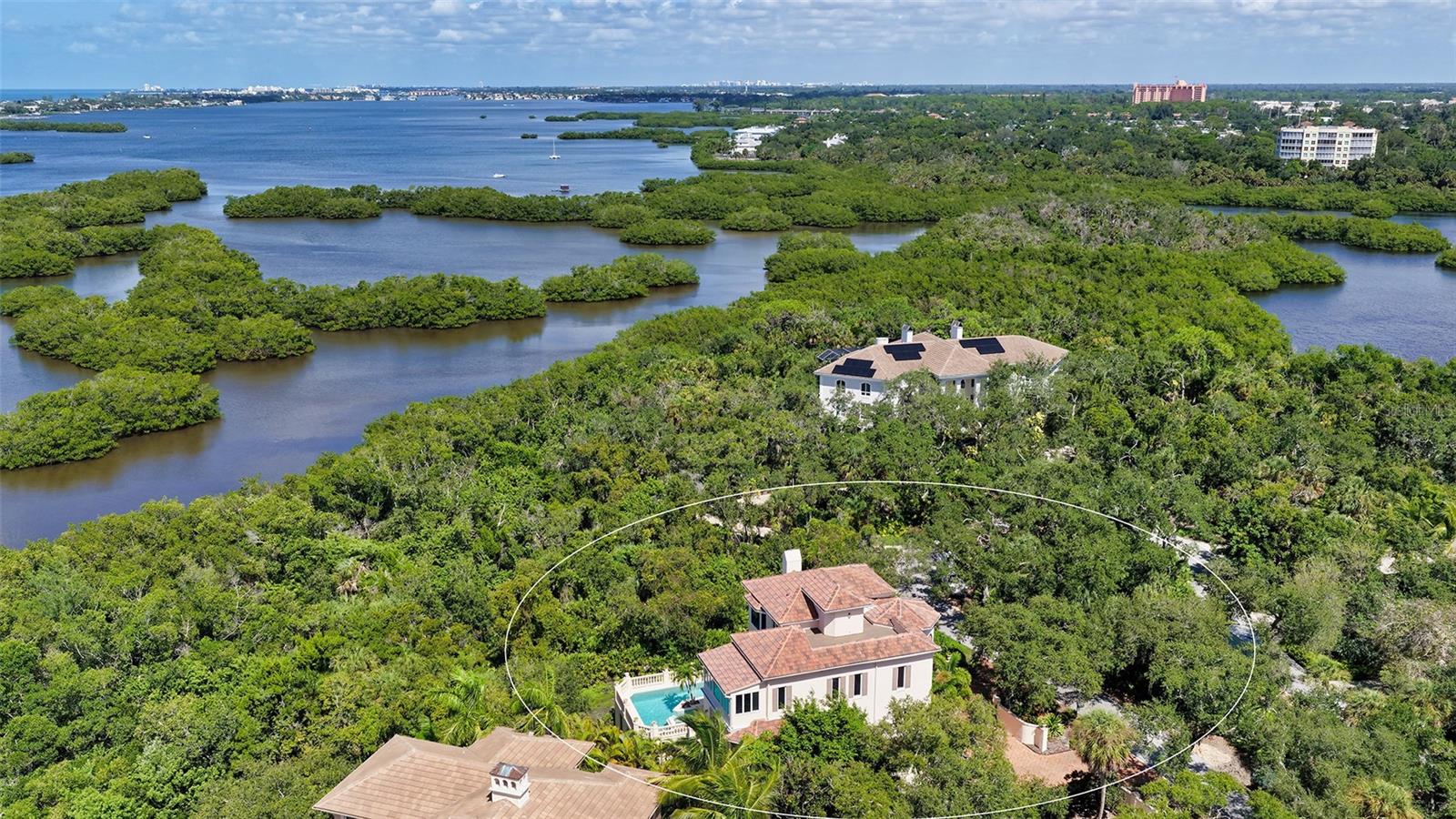 The residence is embraced by mature vegetation and the waterways surrounding Little Sarasota Bay.