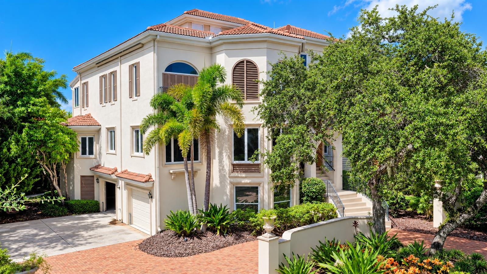 Graceful arched windows, a tile roof and distinctive architectural details give the residence its signature Mizner inspired style.