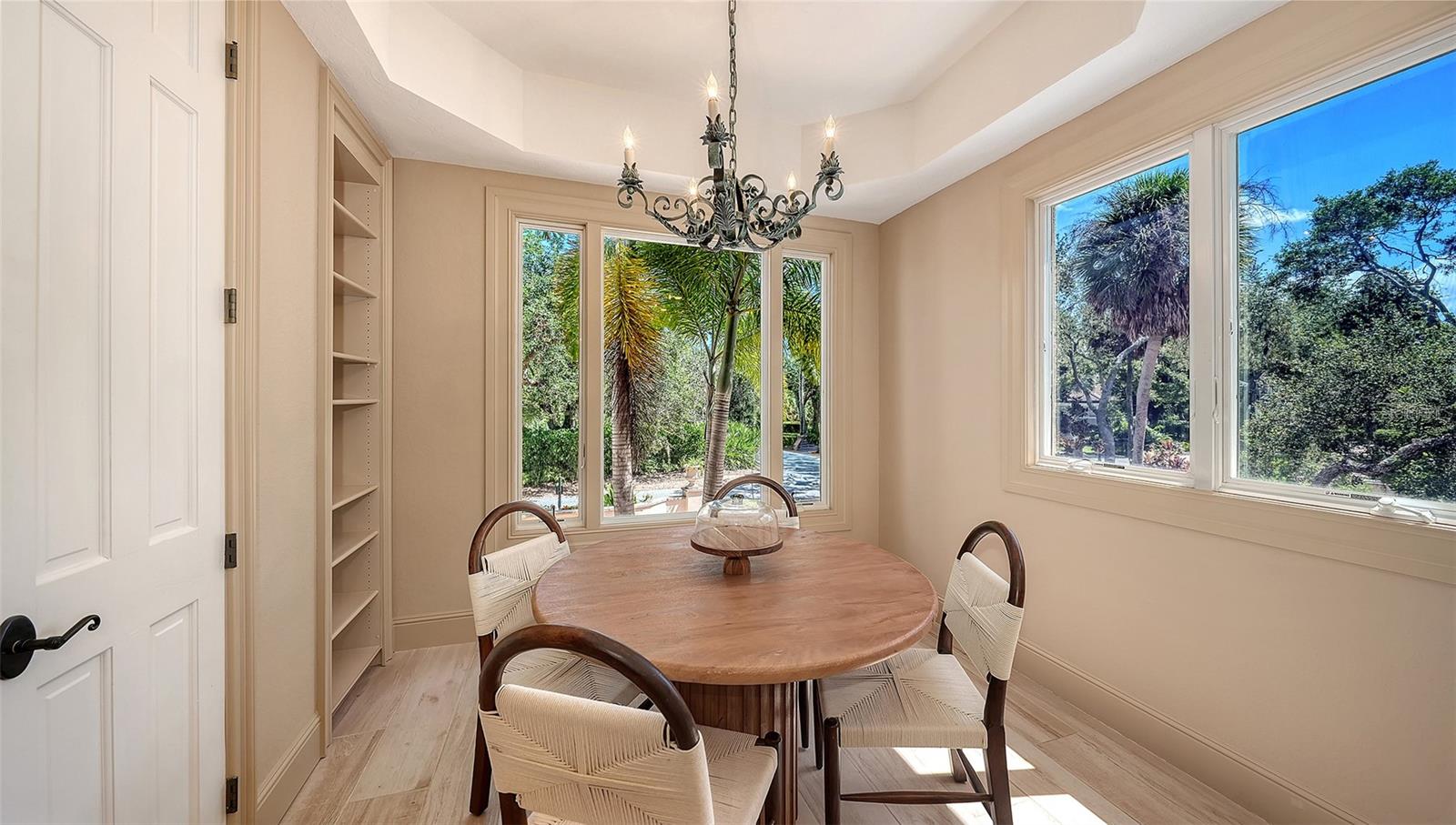 Surrounded by windows and greenery, this intimate dining nook offers a peaceful setting for casual meals.