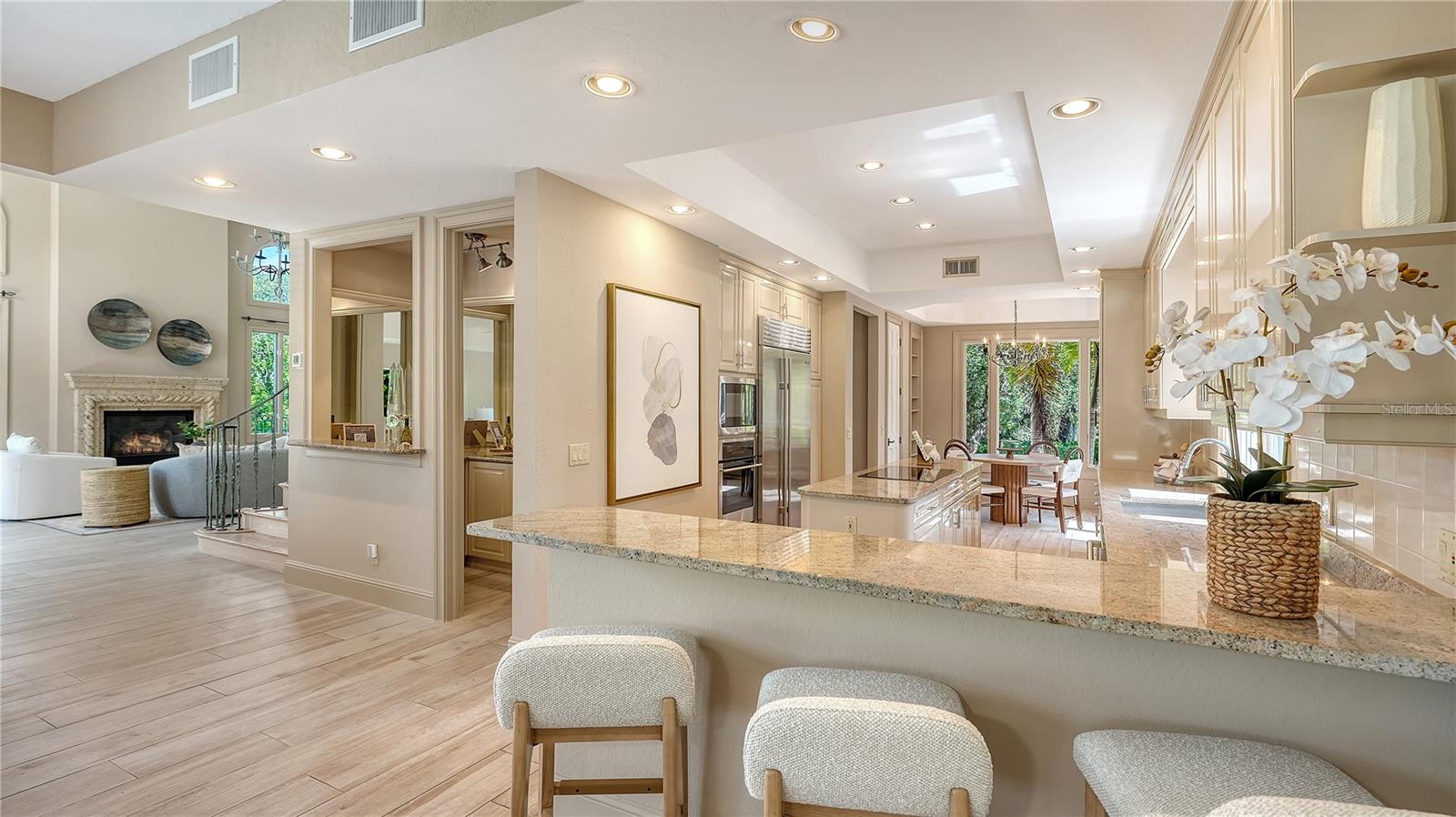 An expansive counter provides abundant workspace and casual seating while connecting the kitchen to the heart of the home.