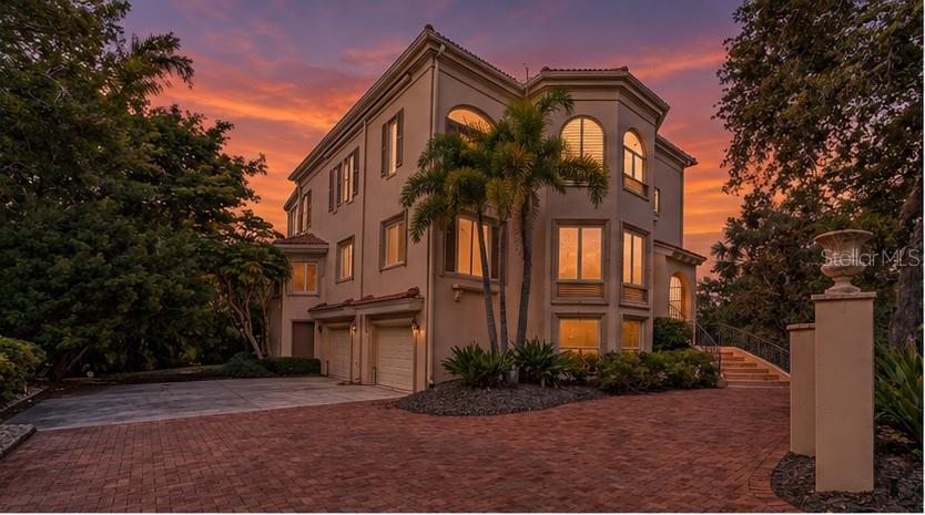 The home's distinctive architecture takes on a dramatic presence beneath Sarasota's colorful evening skies.