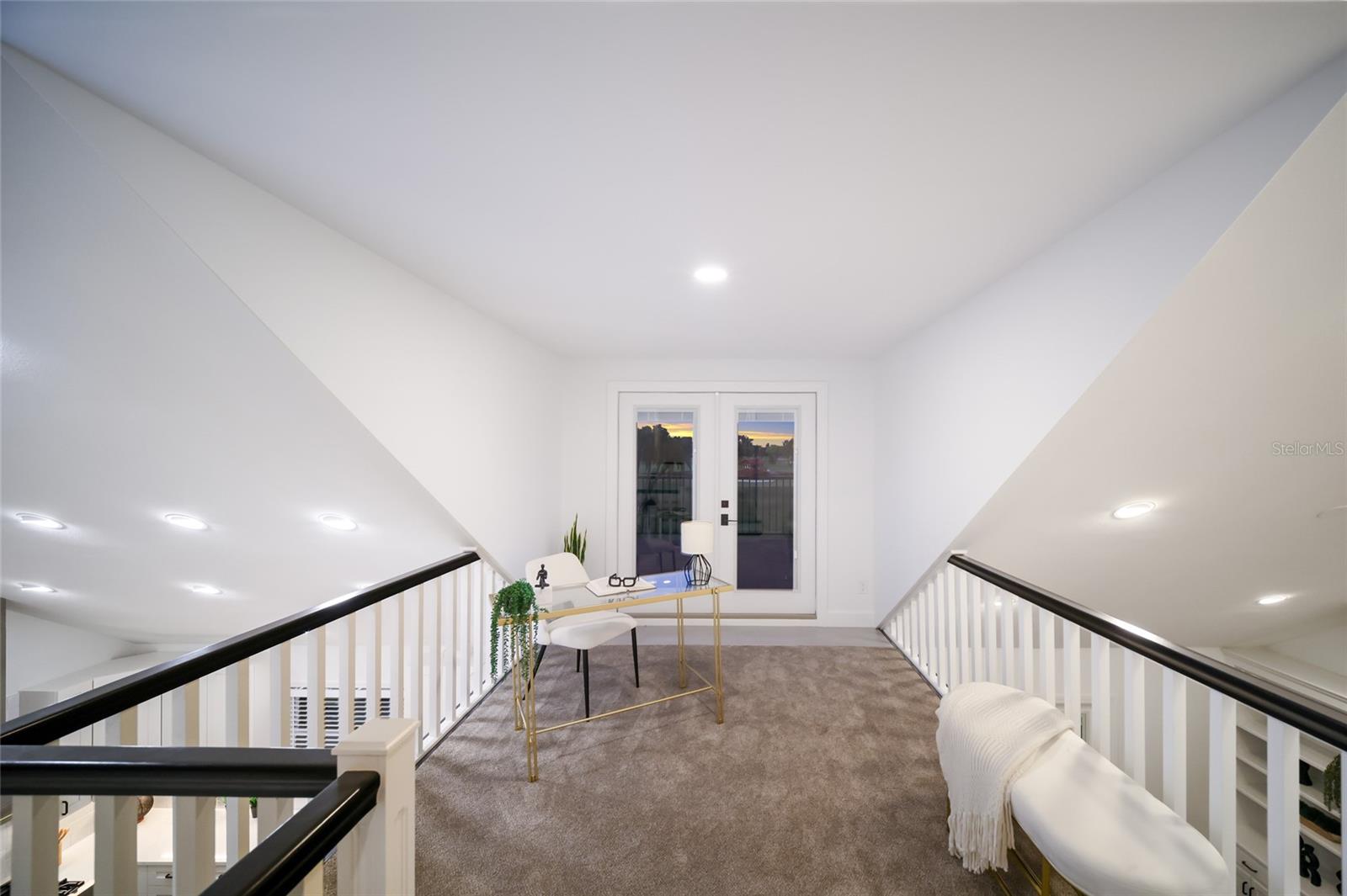 The upstairs loft offers views of the kitchen. and family room.