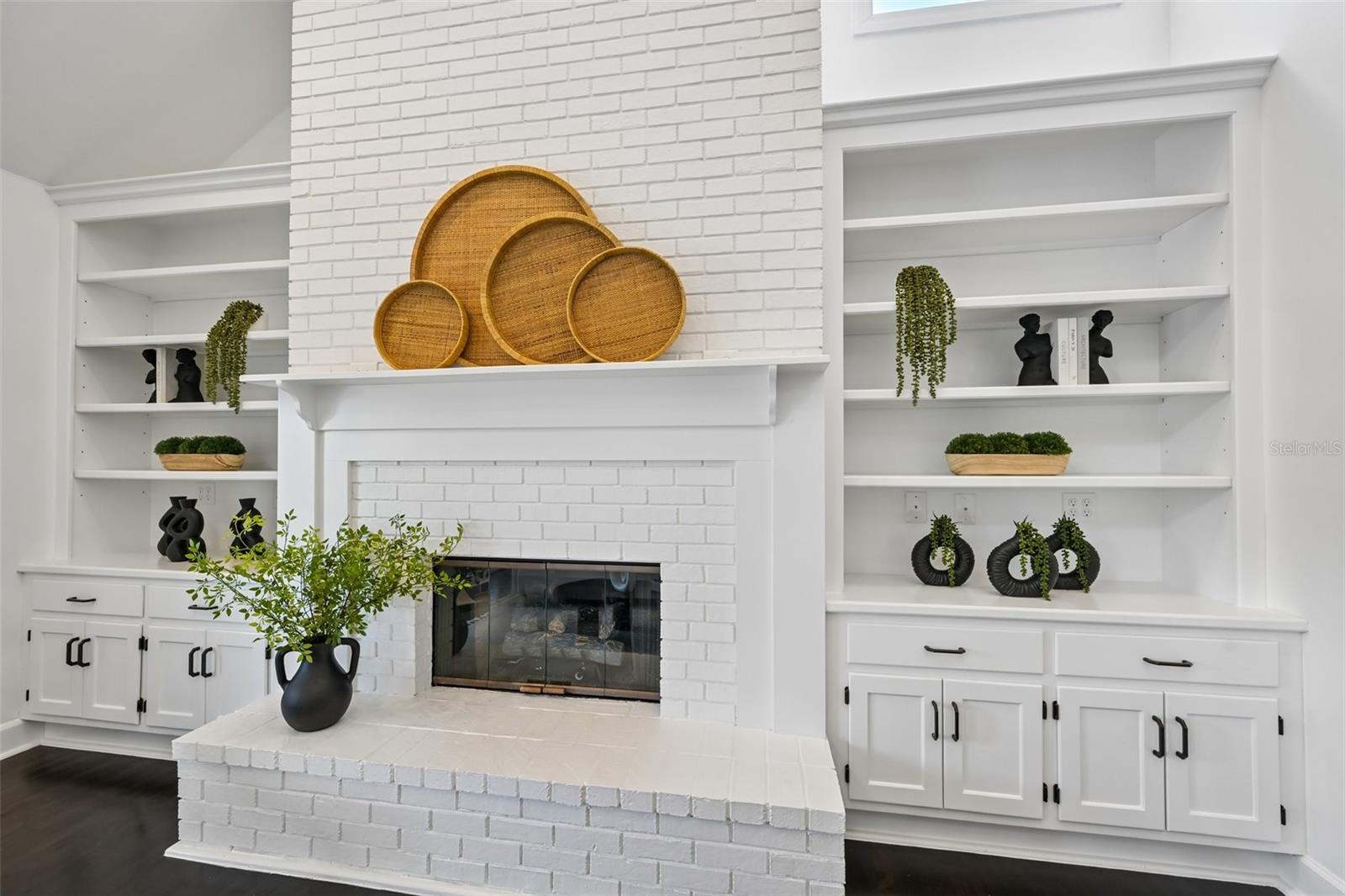 Beautiful white brick fire place with custom built-ins