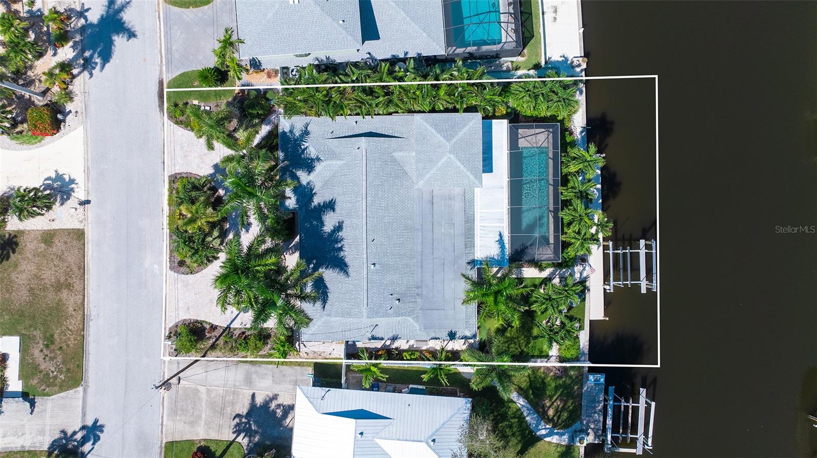 An overhead view shows the home, pool enclosure, and waterfront layout.