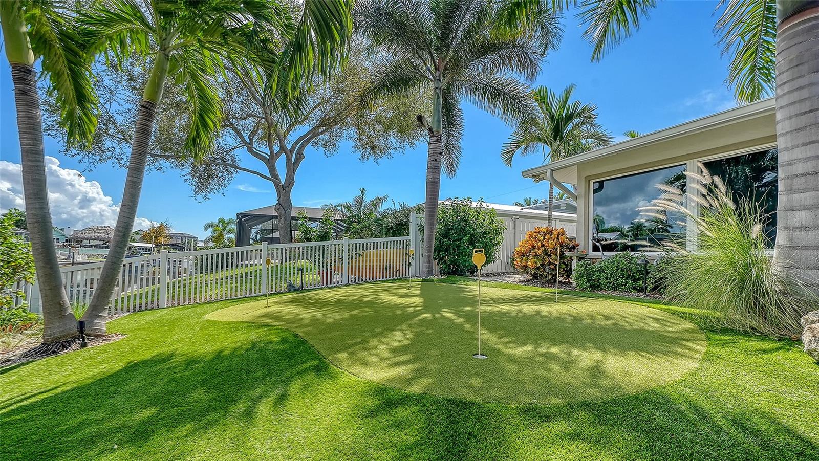 A palm-lined putting green beside the waterfront setting.
