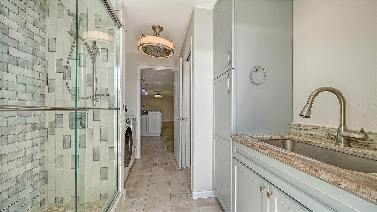 A poolside bathroom with a glass shower for easy refreshment.