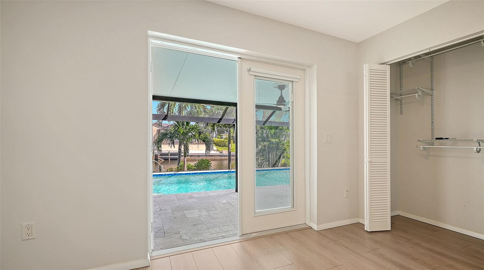 Step toward the pool from this bright bedroom retreat.