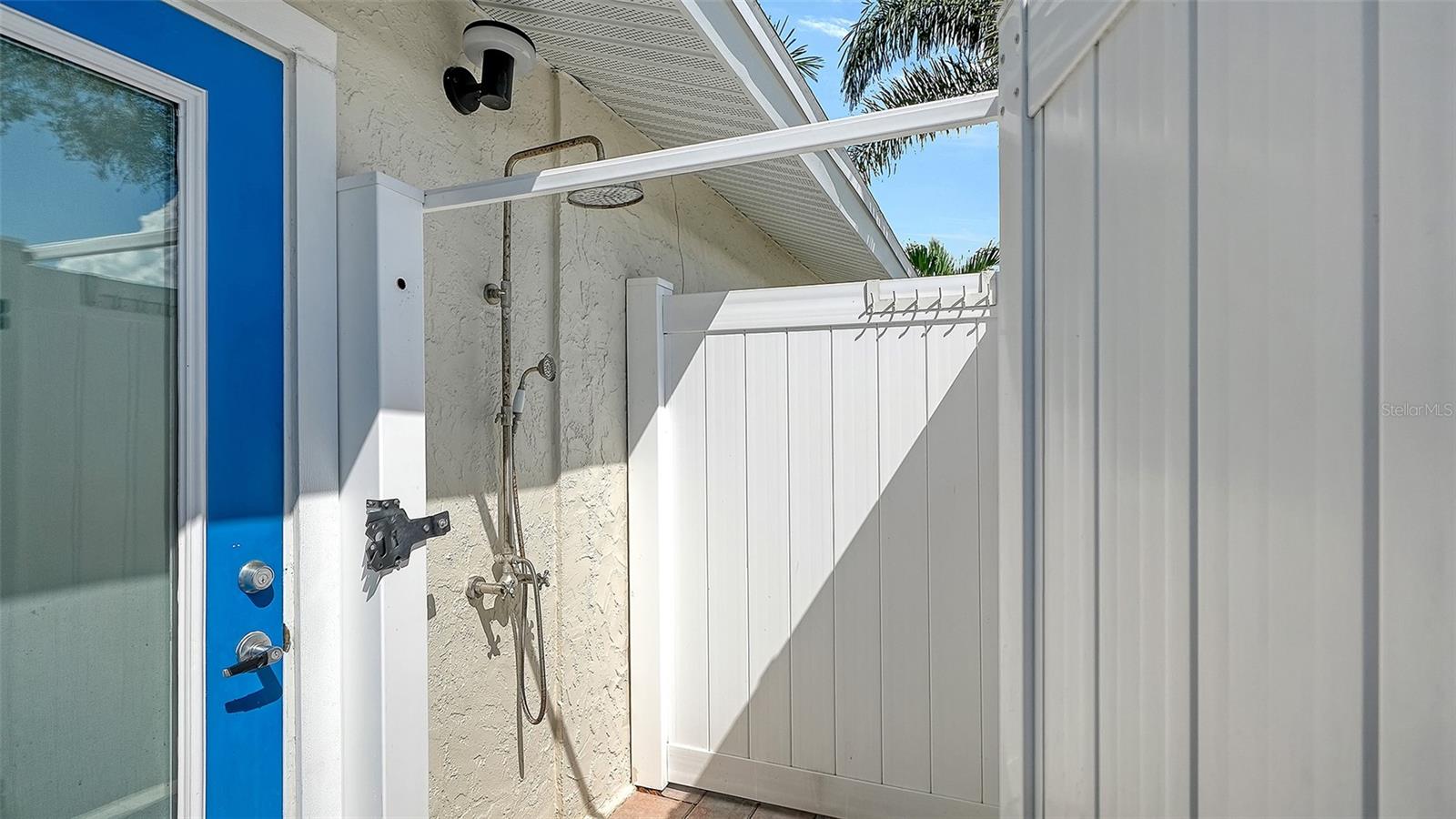 An outdoor shower offers a convenient rinse after pool time.