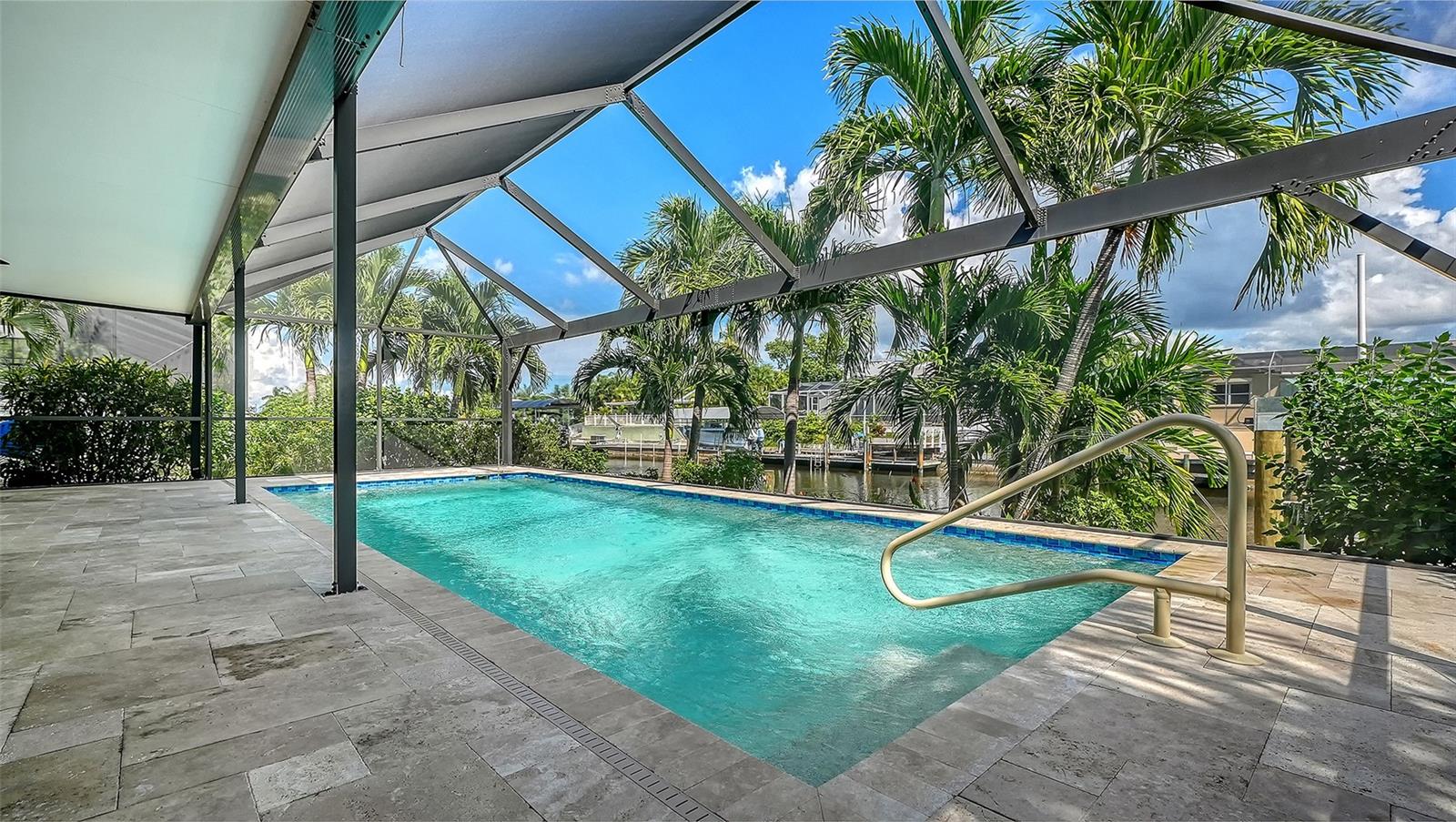 Tropical greenery surrounds your screened pool retreat for privacy.