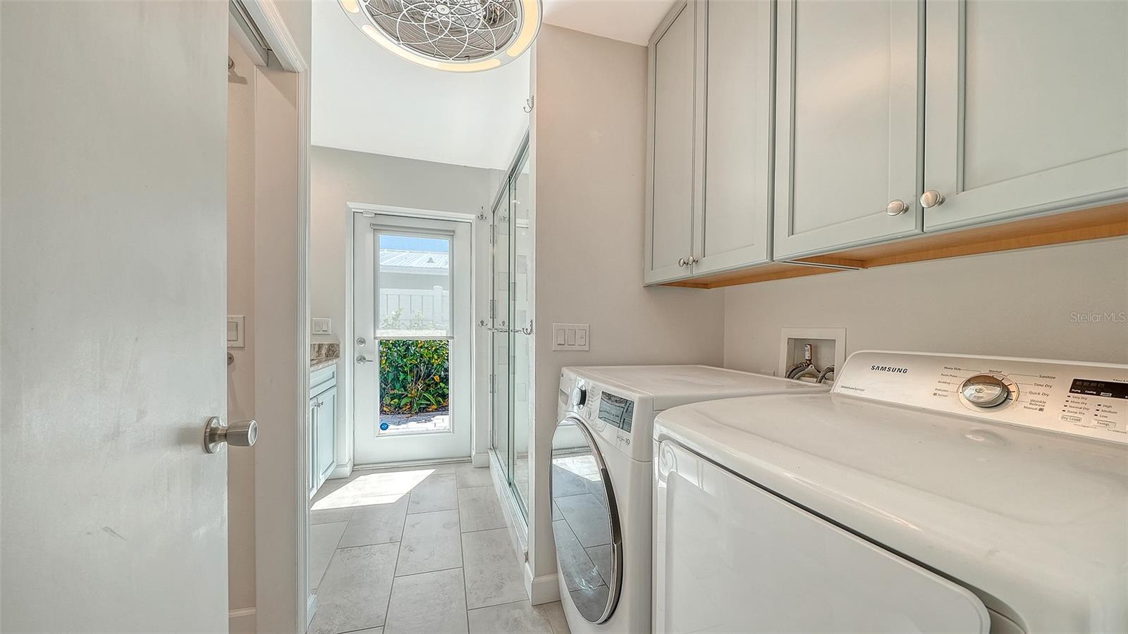 A dedicated laundry area with overhead cabinetry.