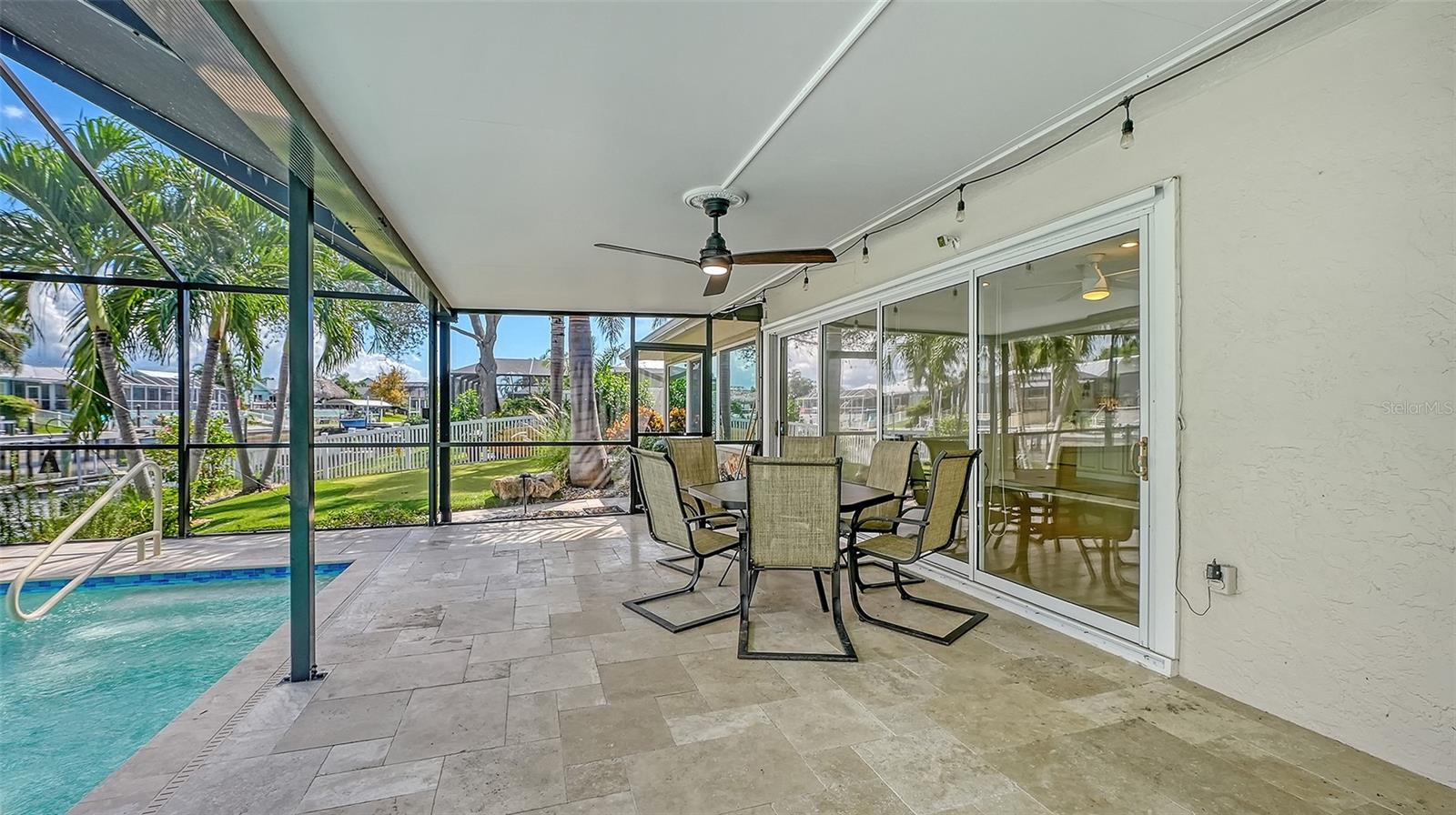 Covered outdoor dining with views of the pool and canal.