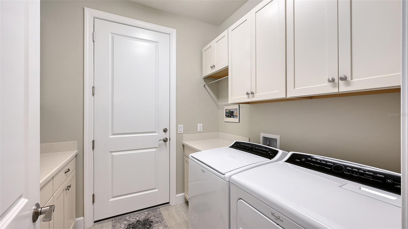 This exceptional laundry room has built-in cabinets on both side of the room for additional storage for your convenience.