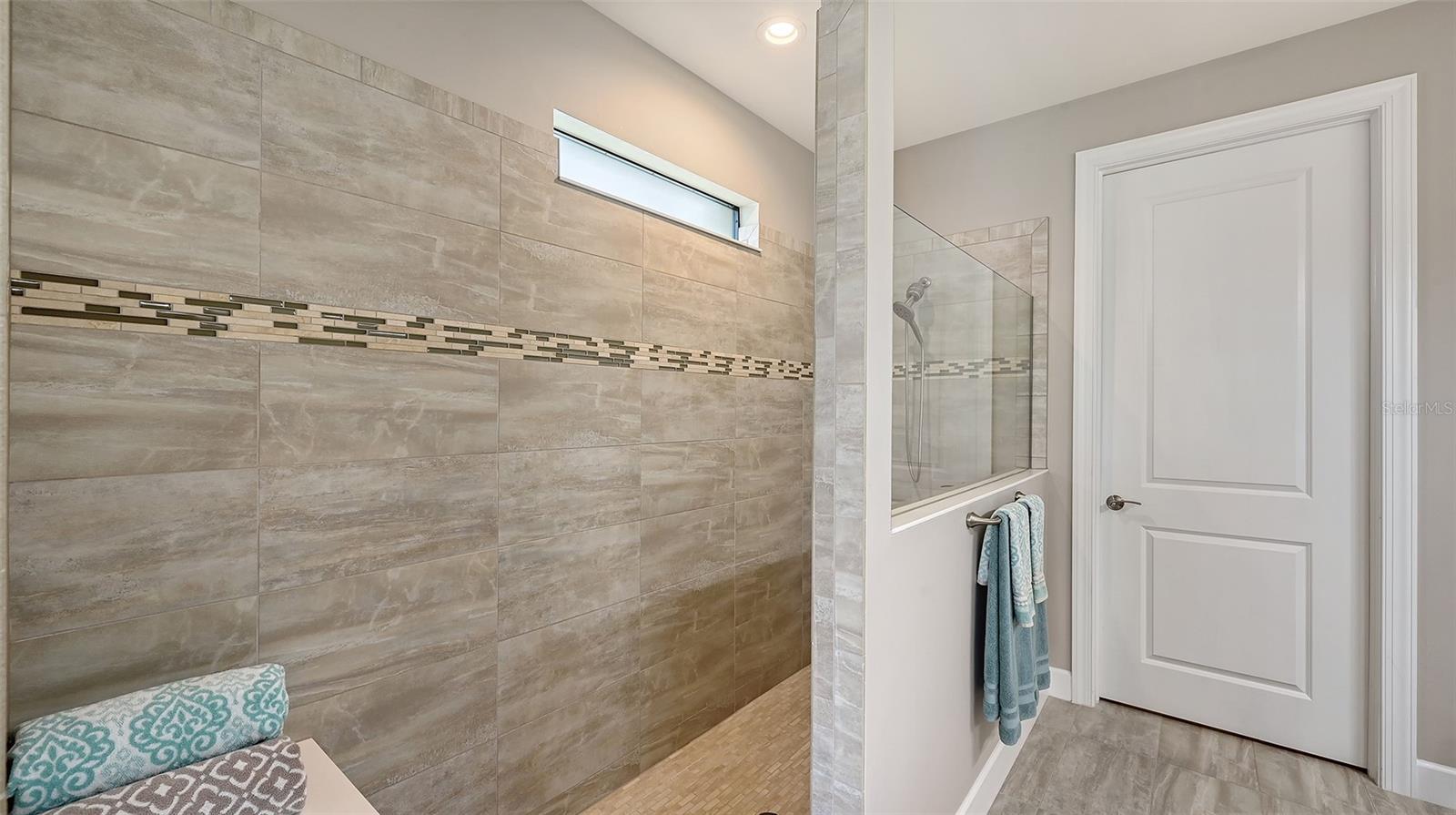 The primary bath offers a spa-inspired retreat, featuring an oversized walk-in shower designed for relaxation and rejuvenation.