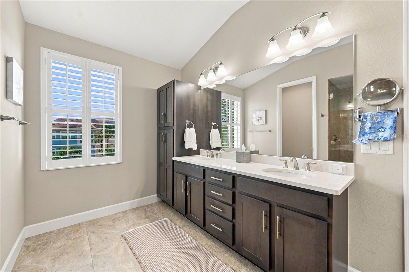 The spacious primary ensuite features dual vanities, a large walk-in shower, a private water closet, and convenient access to one of the suites two walk-in closets.