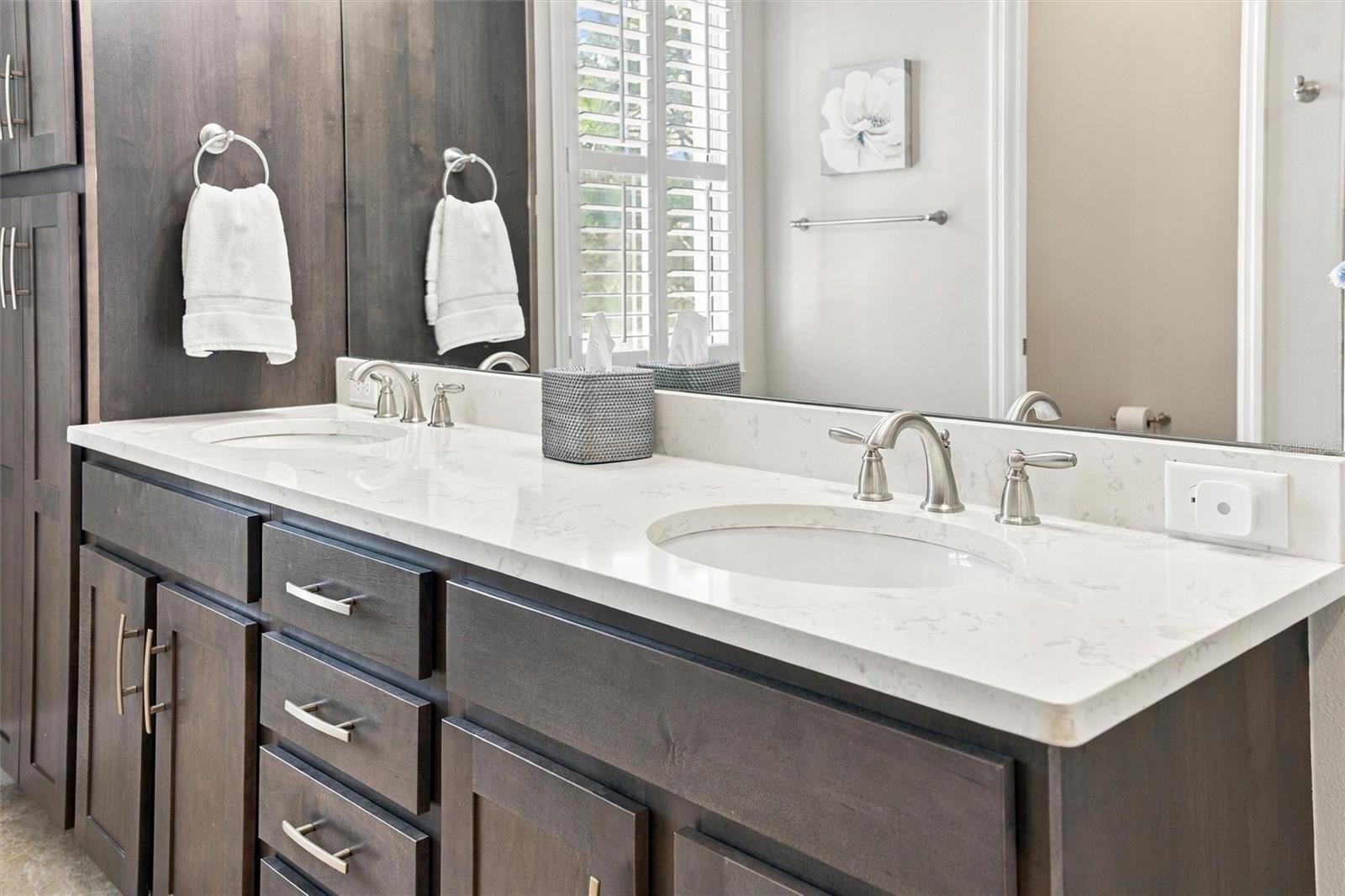 The spacious primary ensuite features dual vanities, a large walk-in shower, a private water closet, and convenient access to one of the suites two walk-in closets.