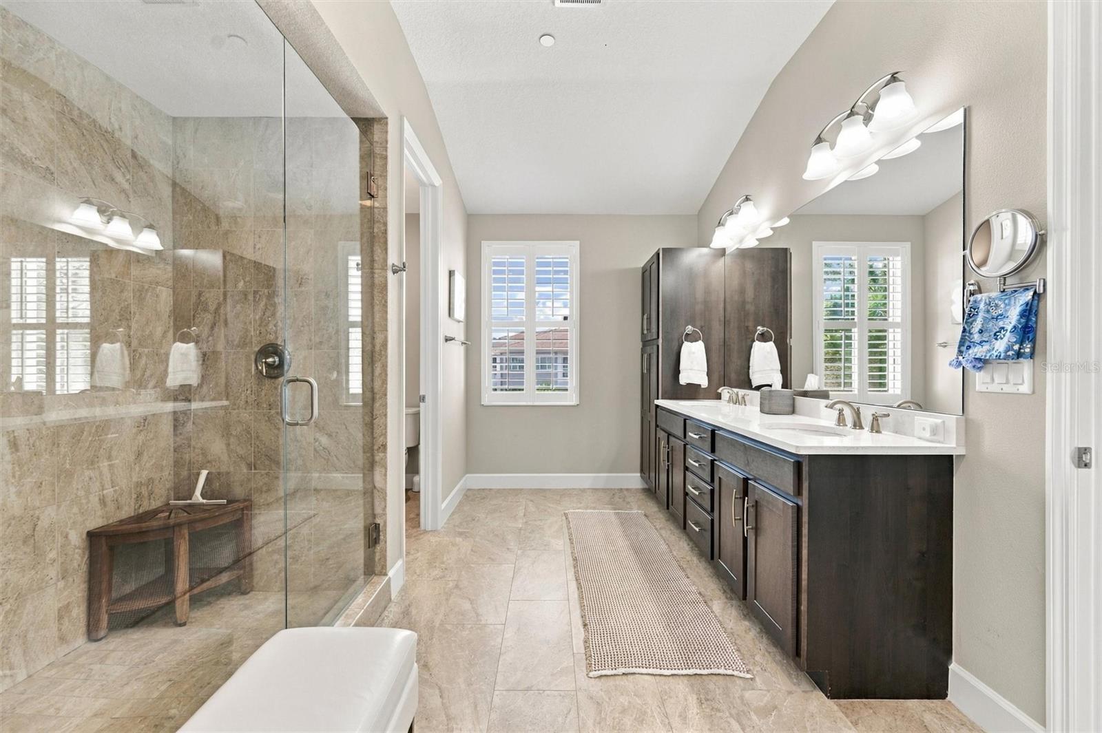 The spacious primary ensuite features dual vanities, a large walk-in shower, a private water closet, and convenient access to one of the suites two walk-in closets.