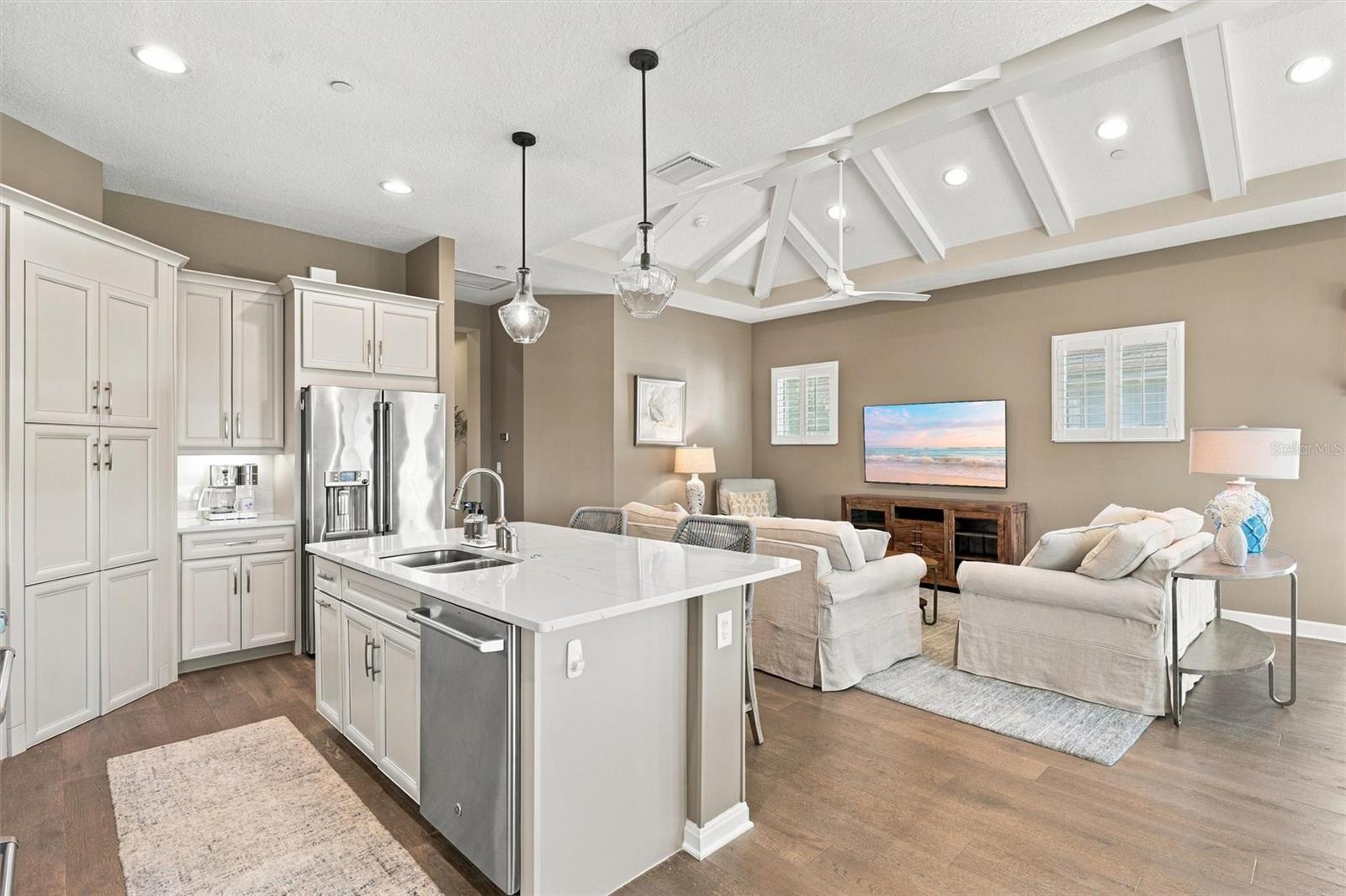 The well-designed kitchen shines with GE Caf stainless steel appliances, elegant quartz countertops, and a spacious walk-in pantry.