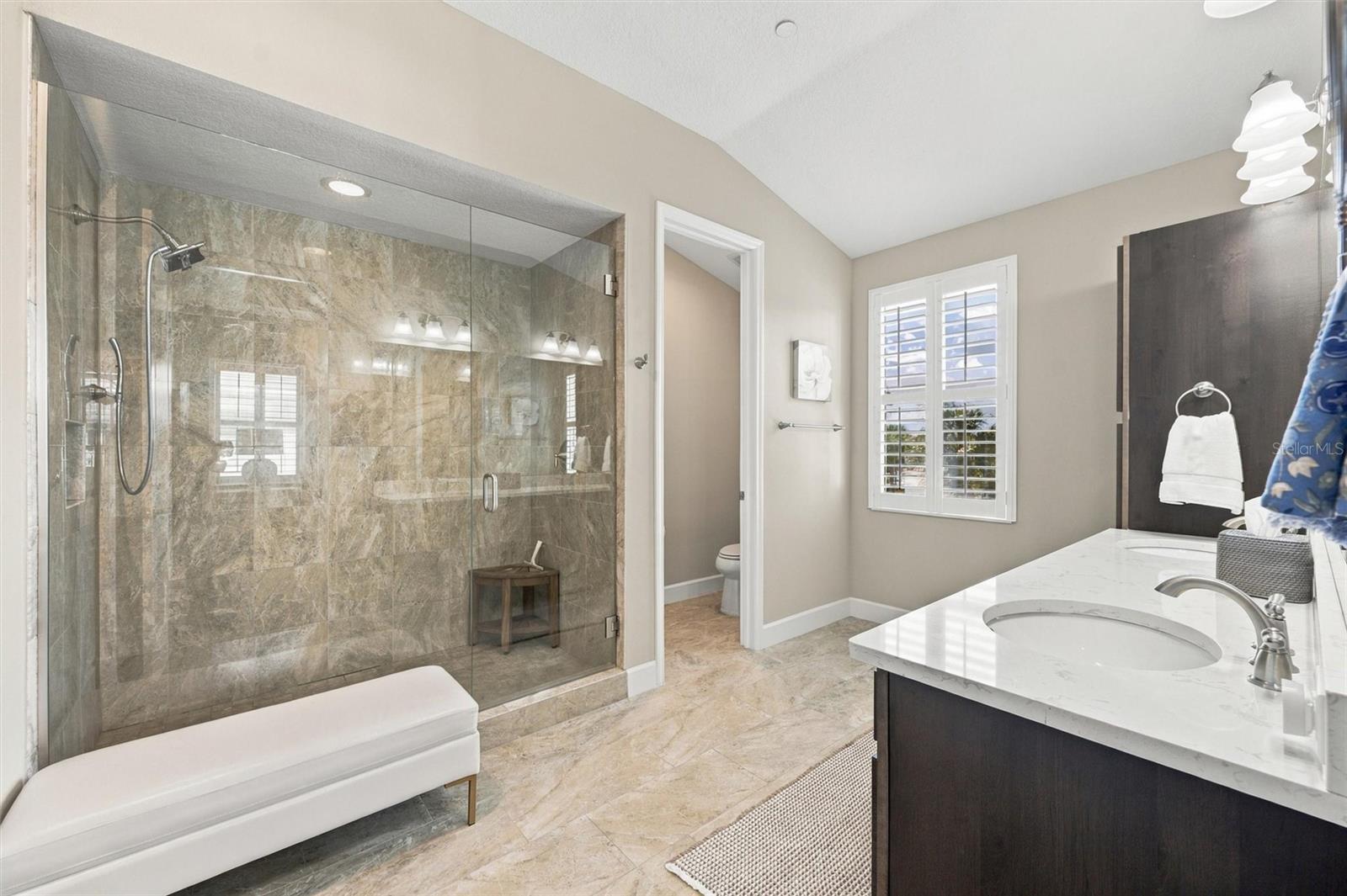 The spacious primary ensuite features dual vanities, a large walk-in shower, a private water closet, and convenient access to one of the suites two walk-in closets.