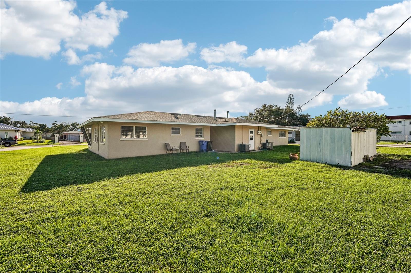 Back of duplex, shared laundry / utility room in center, plus two storage sheds. Oversized lot with a third of an acre!