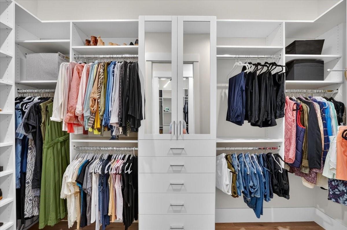 Dual Walk In Closets with Custom Cabinetry and Shelving.