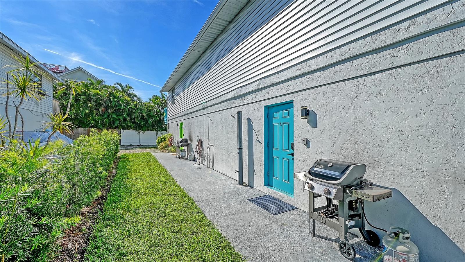 Both units have left side entrances. Blue door, Unit A. Green door, Unit B. Both units have a propane grill.