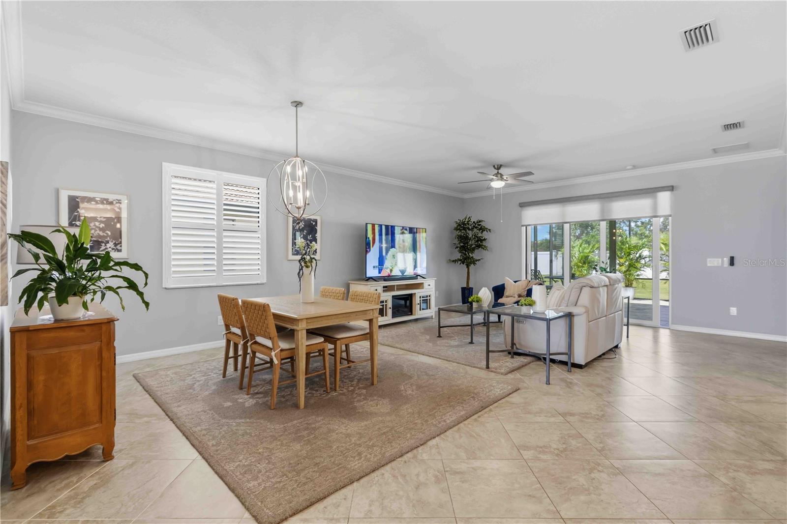 Dining and Living Areas-plantation shutters and motorized shade to the Lanai