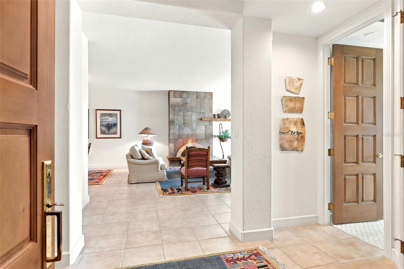 The foyer opens up to the main living area, the primary suite and the kitchen.