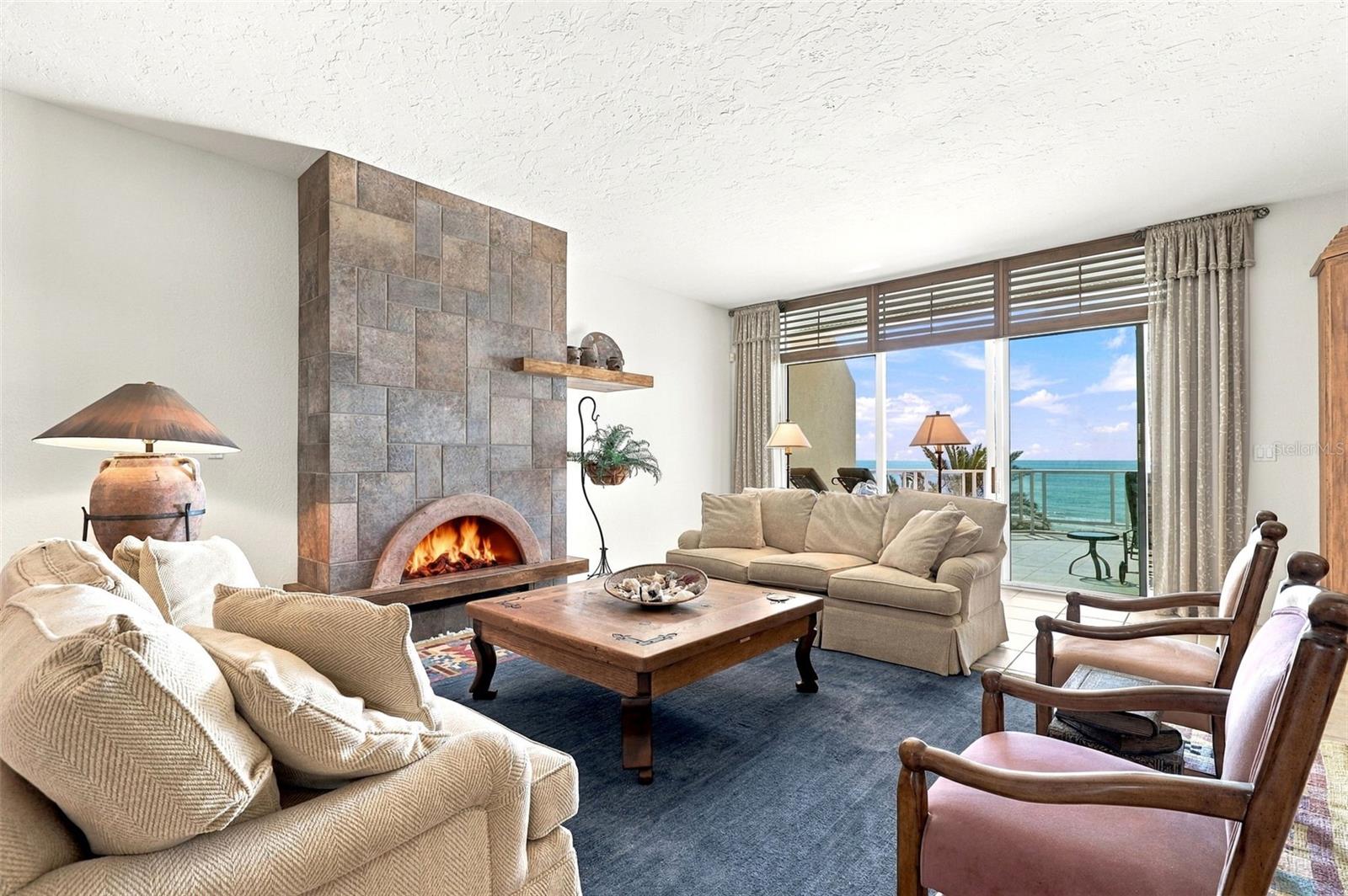 The living room has built-in cabinetry, a gas fireplace, and glass sliders onto a large balcony.