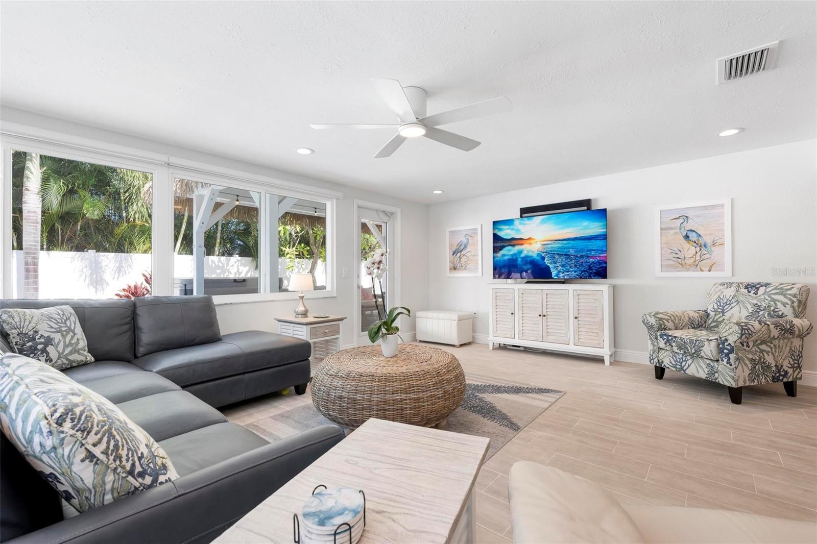 Open concept living area with access to the heated pool and tikki covered pergola