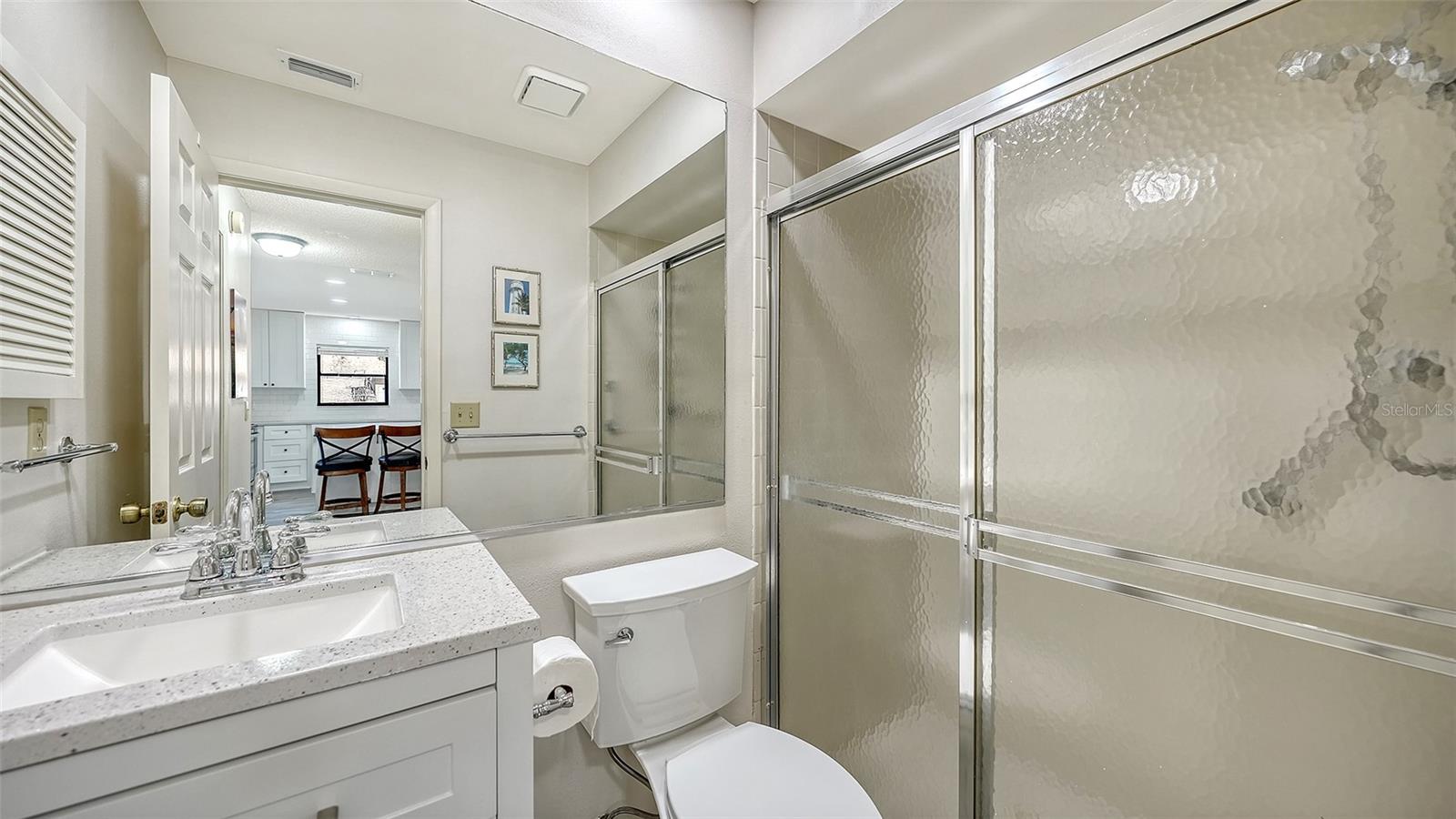 Guest bathroom with updated vanity and walk-in shower.