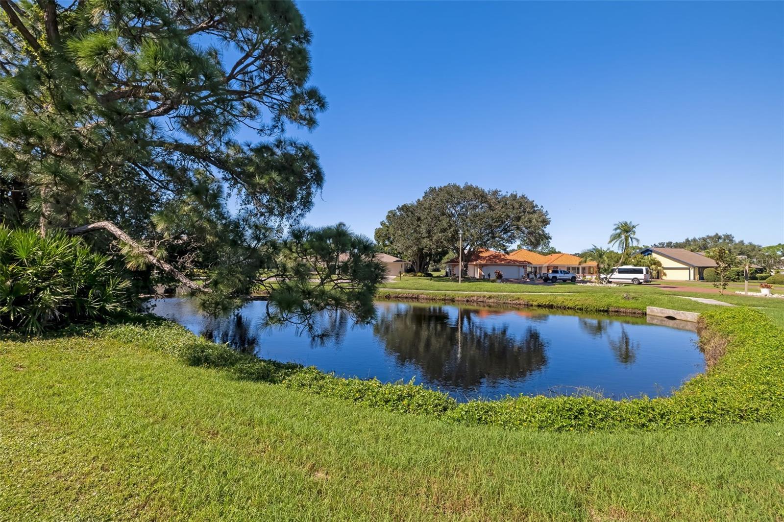 Serene pond along the side of the home, a peaceful water view.