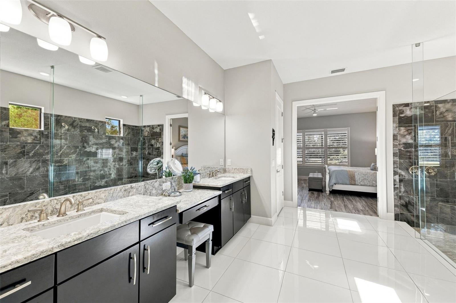 Primary Bathroom shower with dual sinks and vanity